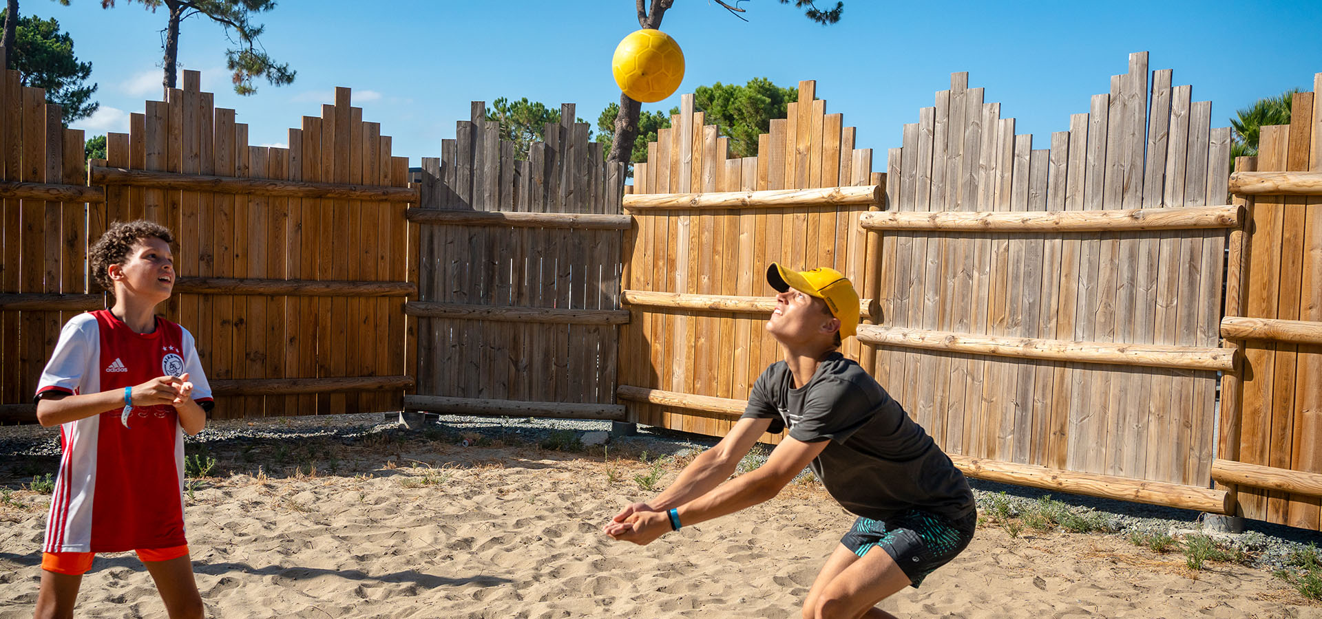 Camping san damiano aire de jeux garcons qui jouent au volley ball
